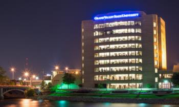 lit building at night with 'Grand Valley State University' sign