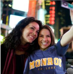 two women selfie with 'monroe college' hoodie in Times Square