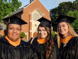 graduates in regalia with chapel in background