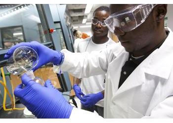 scientists pouring liquid in lab